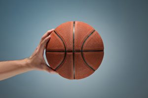 Low key shot of a hand holding a basket ball Low key shot of a hand holding a basket ball at studio